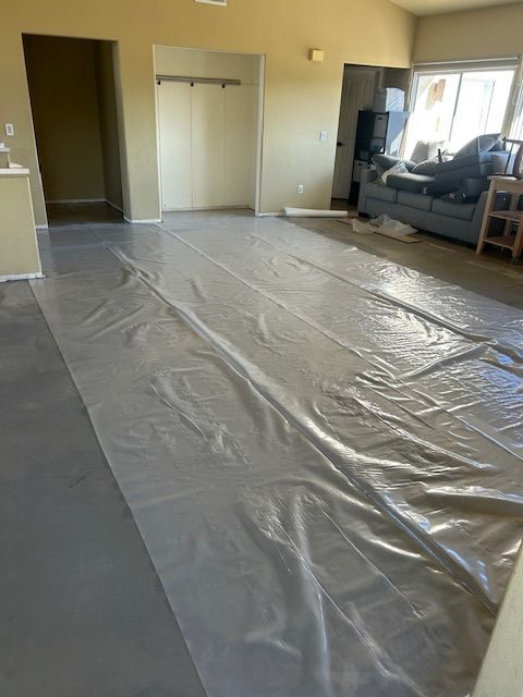 A living room with a large piece of plastic on the floor.