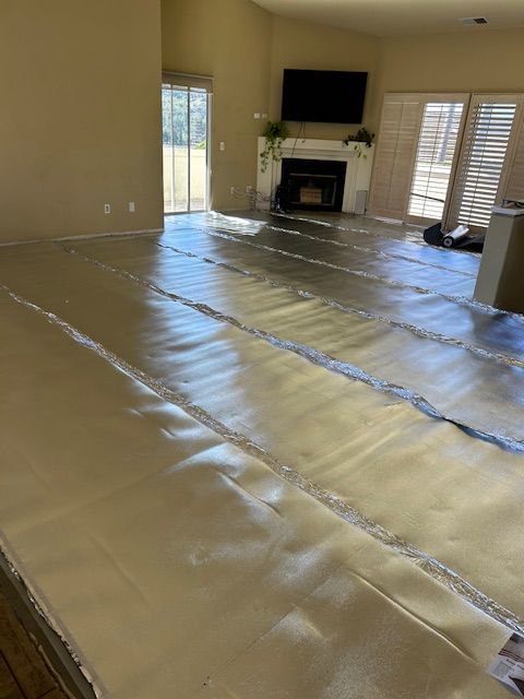 A living room with a lot of aluminum foil on the floor.