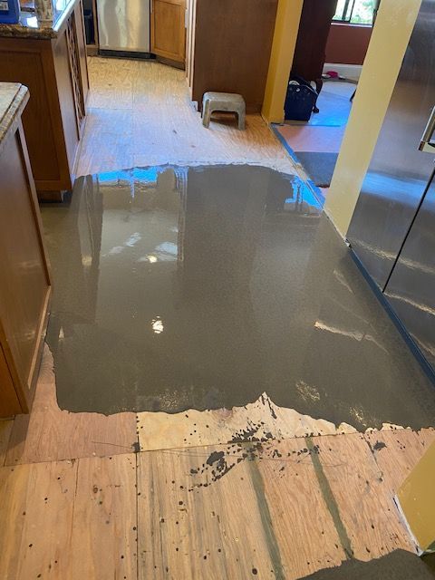 A kitchen floor with a lot of concrete on it