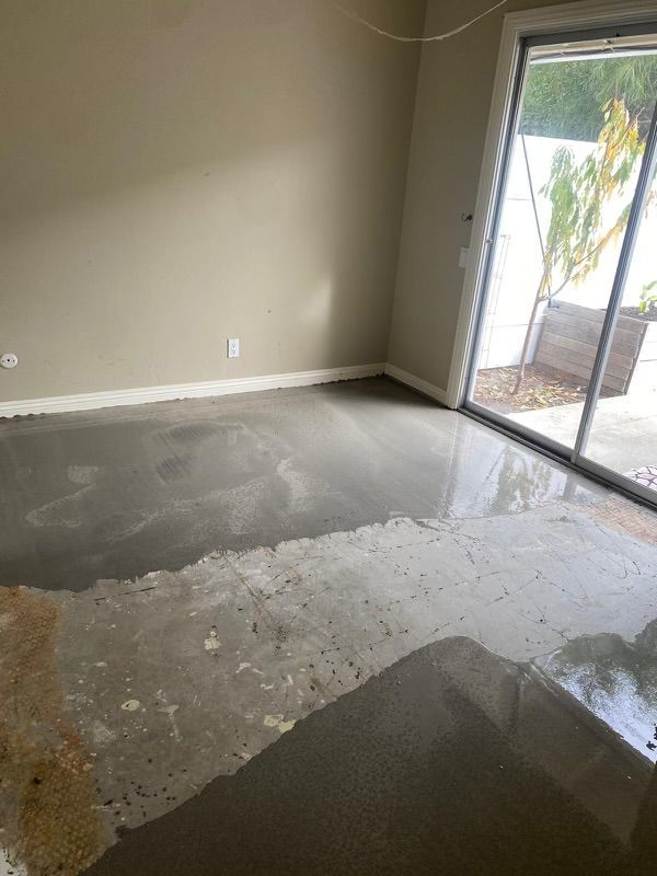 A room with a sliding glass door and a concrete floor.