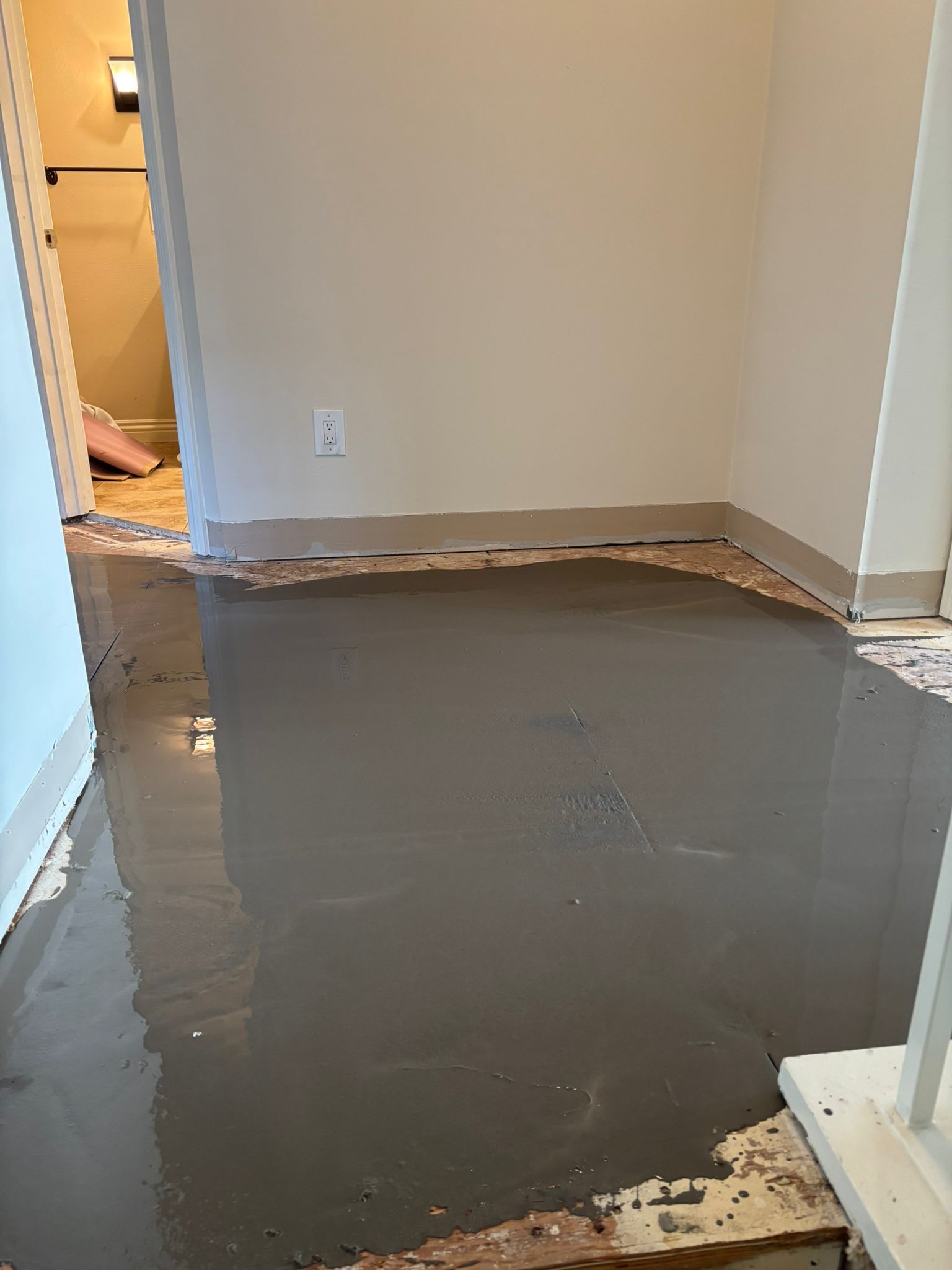 A hallway with a lot of water on the floor.