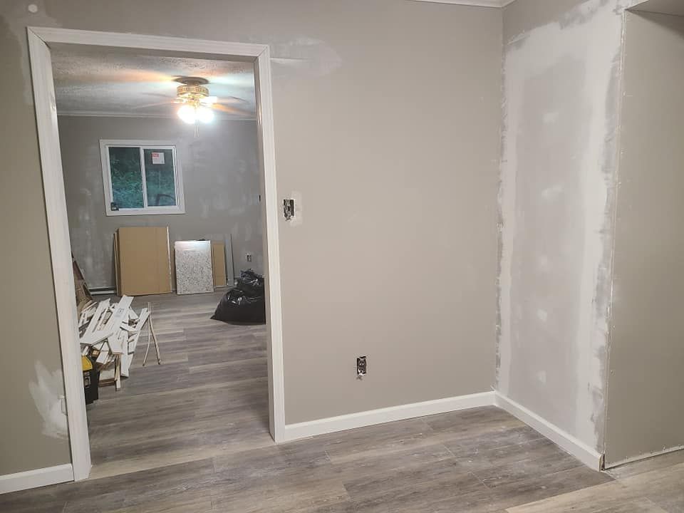 Room interior with gray walls, doorway, and new flooring under renovation.
