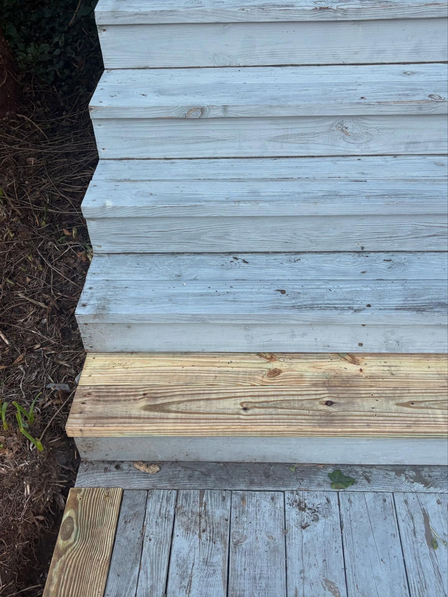Weathered wooden outdoor steps, some painted blue-gray, others bare wood.