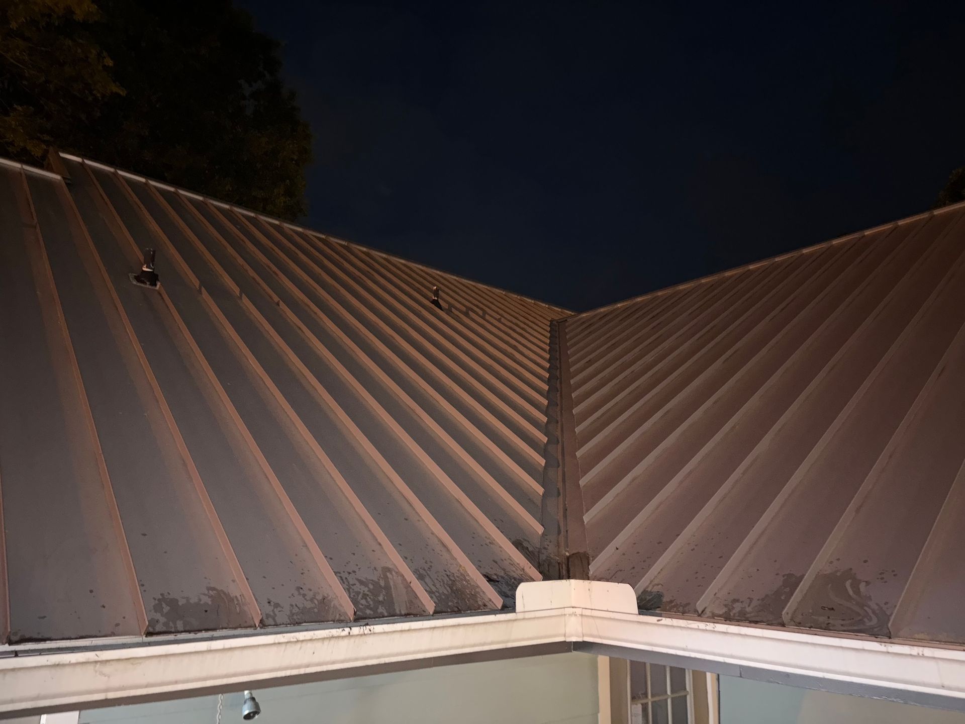 Metal roof angled toward a dark night sky.