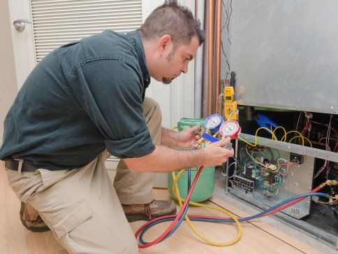 HVAC technician charging a heat pump with refrigerant