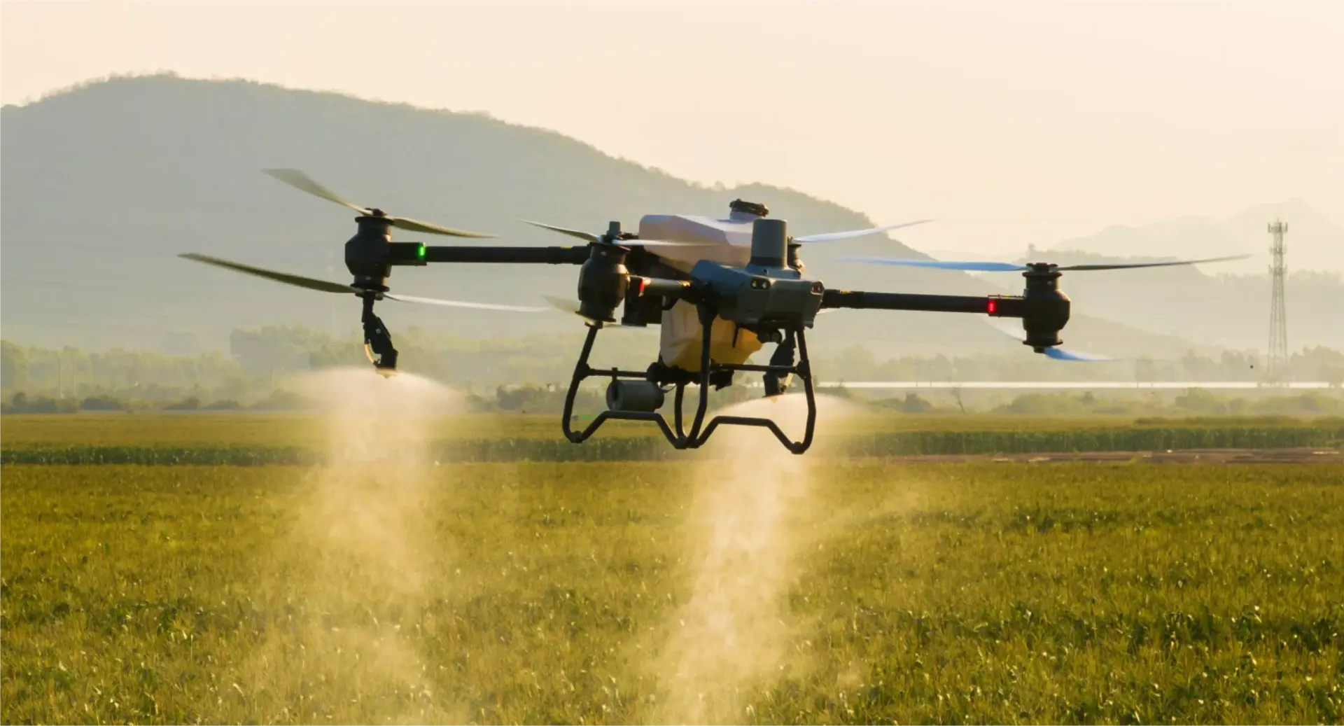 Um drone pulverizando uma plantação com montanhas ao fundo