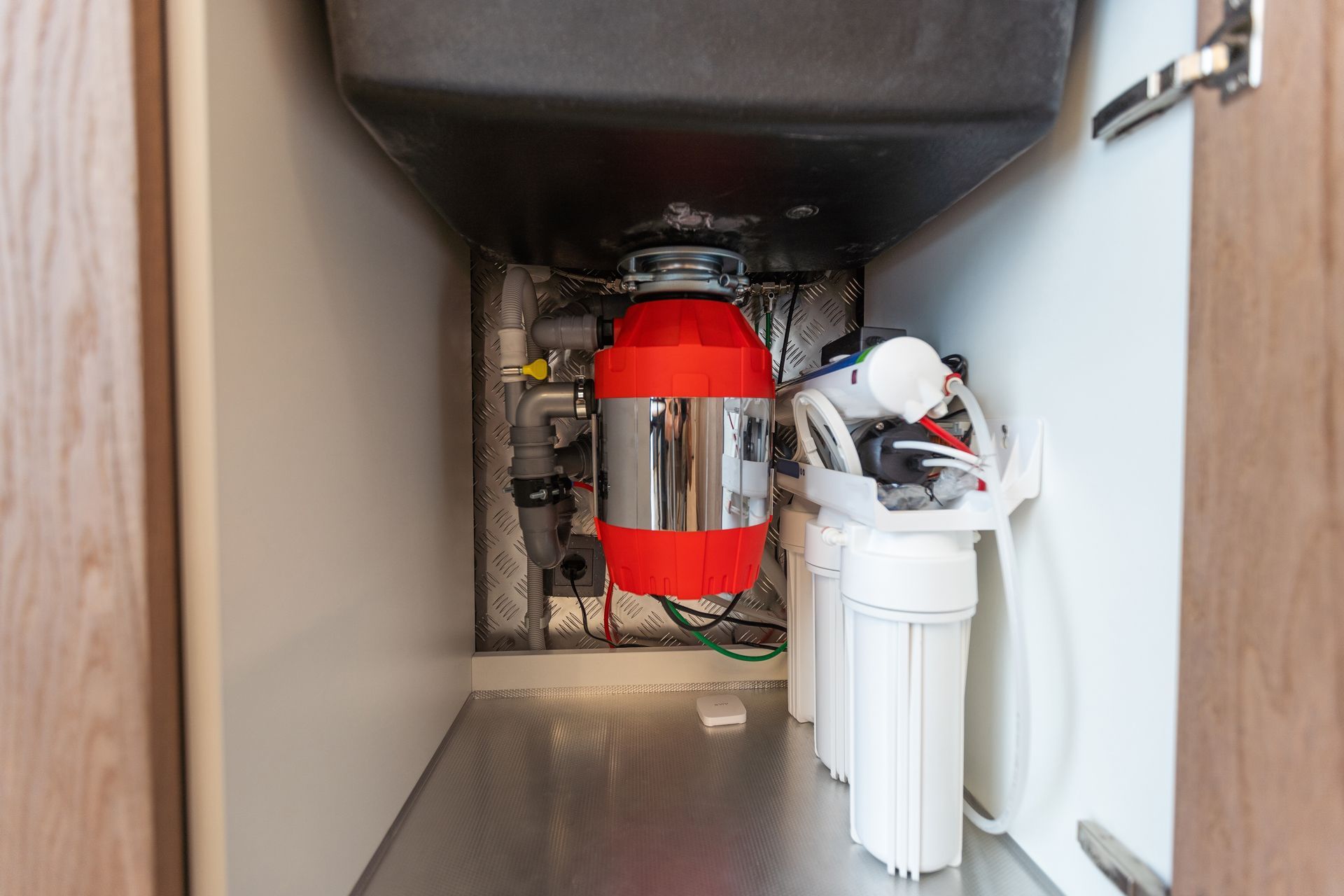 Garbage disposal unit and water filter system under a kitchen sink.