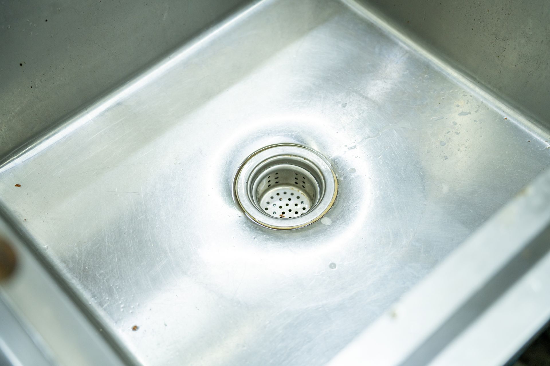 Stainless steel kitchen sink with drain.