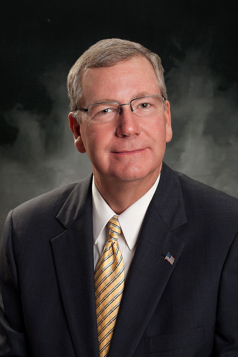 A man in a suit and tie is wearing glasses