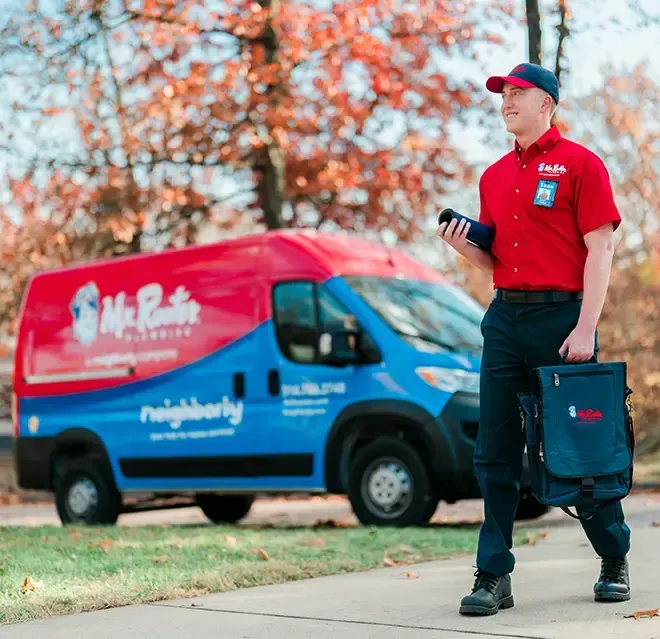 A professional wearing a red uniform and cap shows a tablet screen to a person while standing in a home.