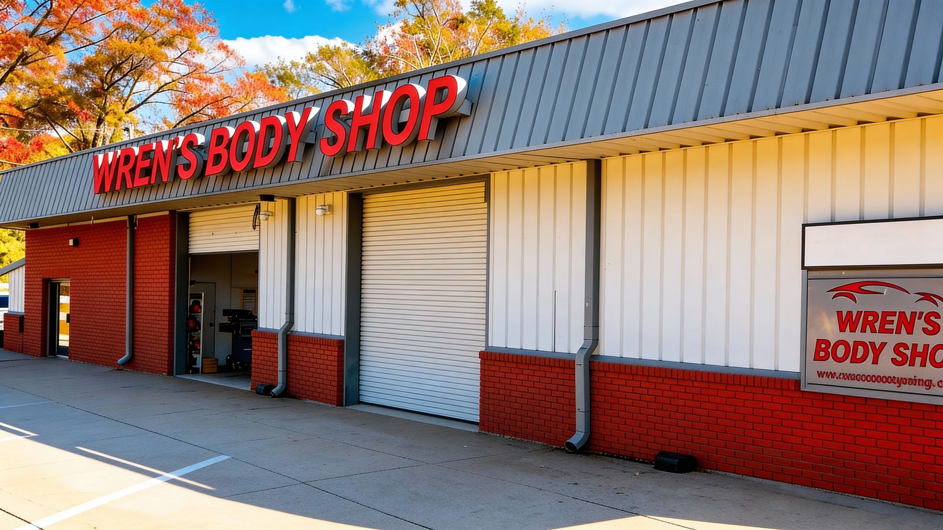 Wren's Body Shop exterior with red brick, white walls, and a large garage door. Red sign with the business name.