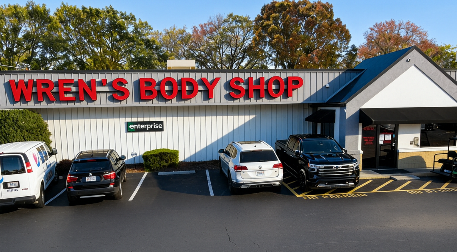 Wren's Body Shop with cars parked outside, and a sign for Enterprise.