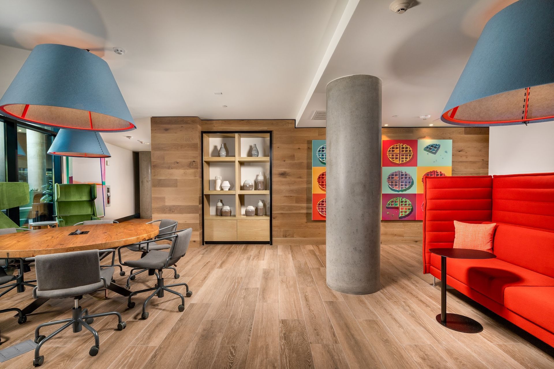 Modern office space with a conference table, lounge area, and decorative elements.