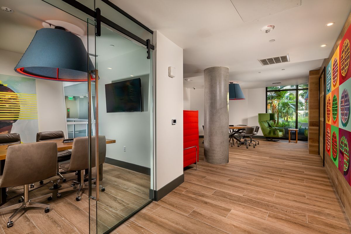 Interior office space with meeting room, lounge area, and colorful wall art.