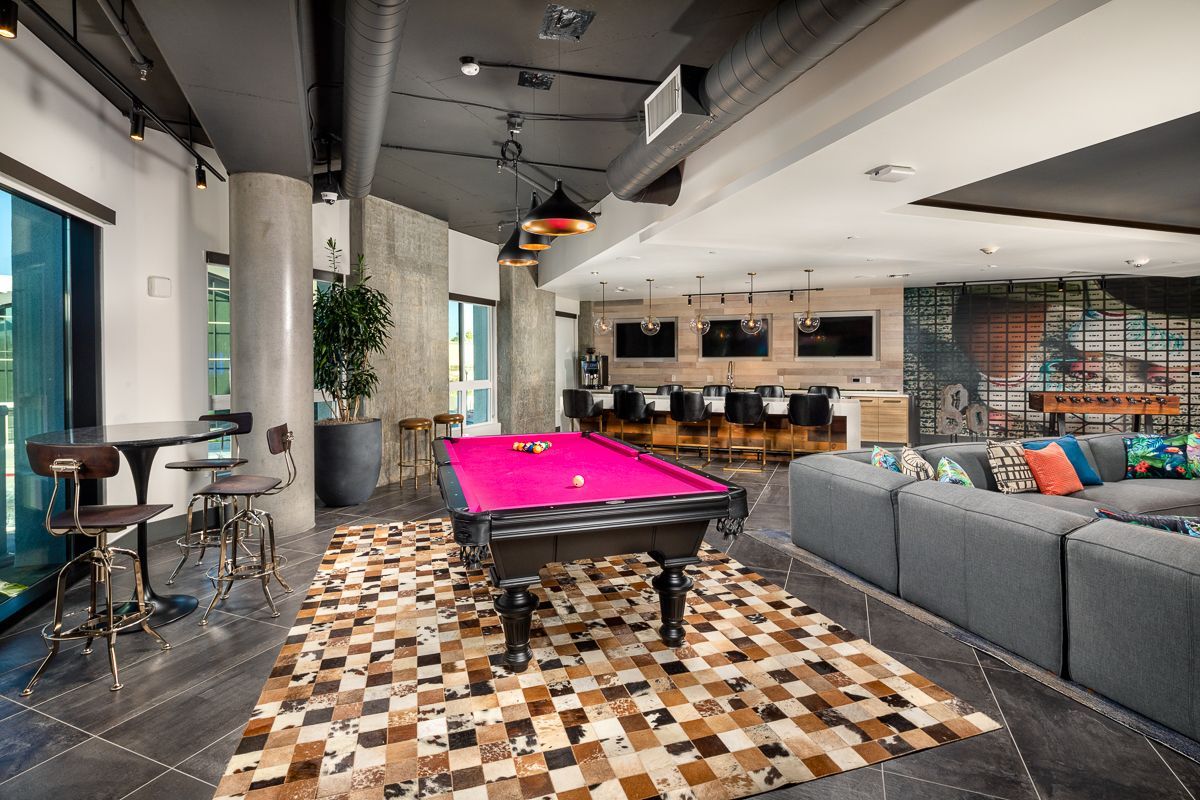 Game room with pool table, bar, and seating area.