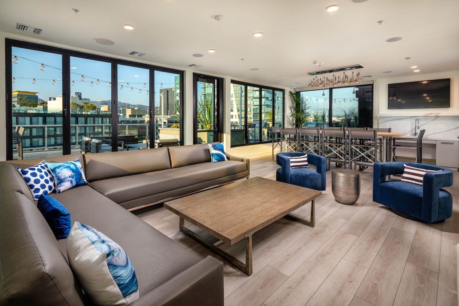 Modern lounge area with large windows, seating, and city view.