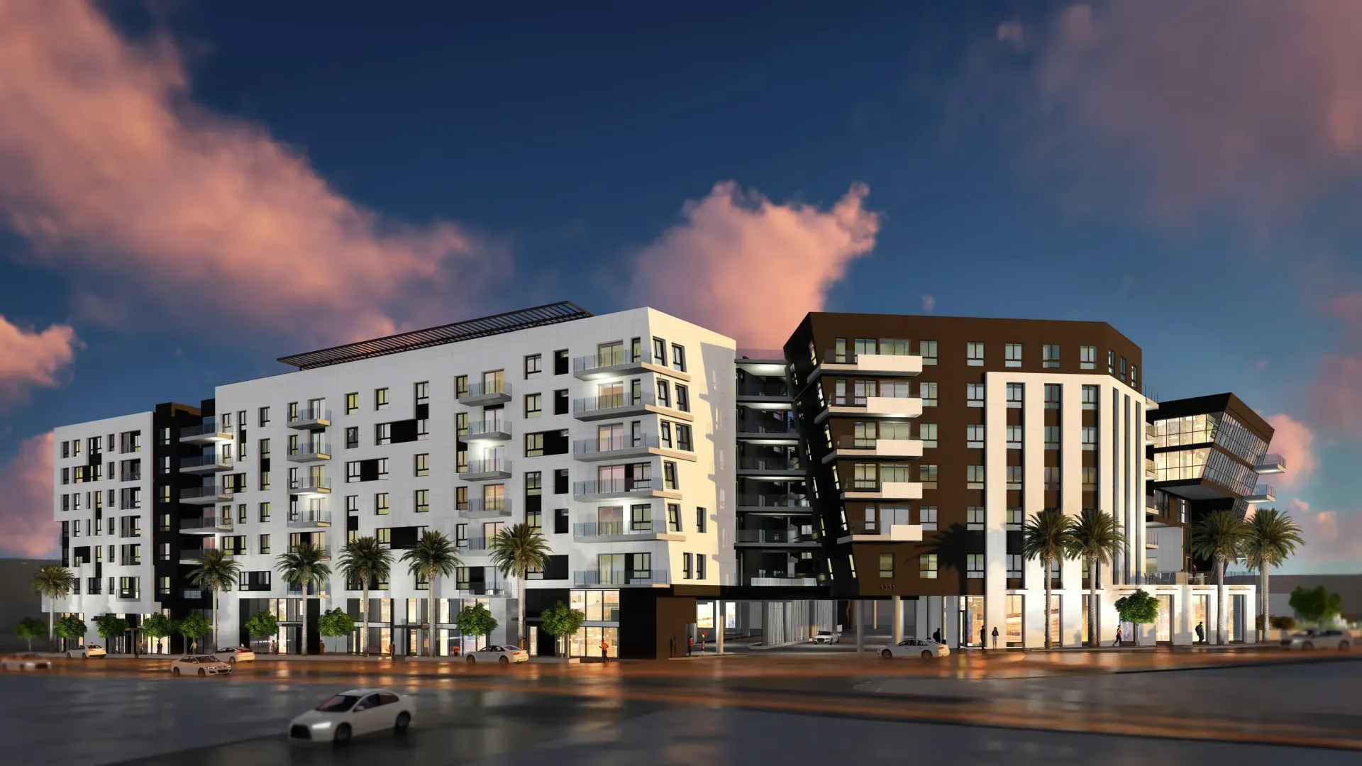 Modern multi-story apartment building with white and brown facades under a sunset sky.