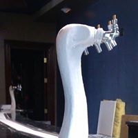 A white swan beer tap is sitting on top of a table in a room.