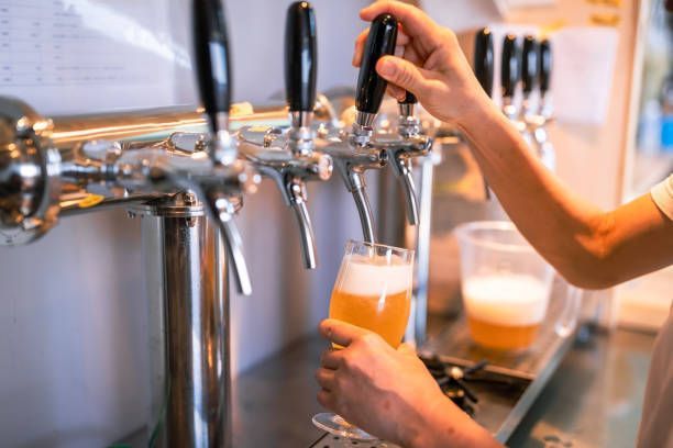 Craft beer being poured into beer glasses from a beer dispenser.
