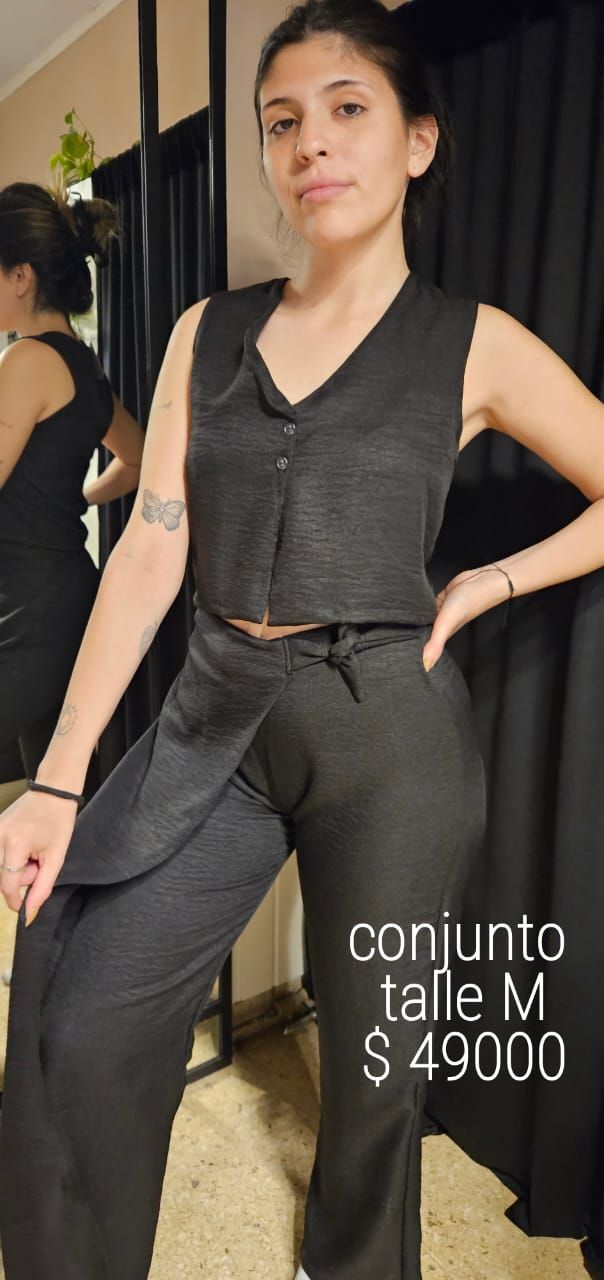 Mujer vestida de negro, de pie en una habitación