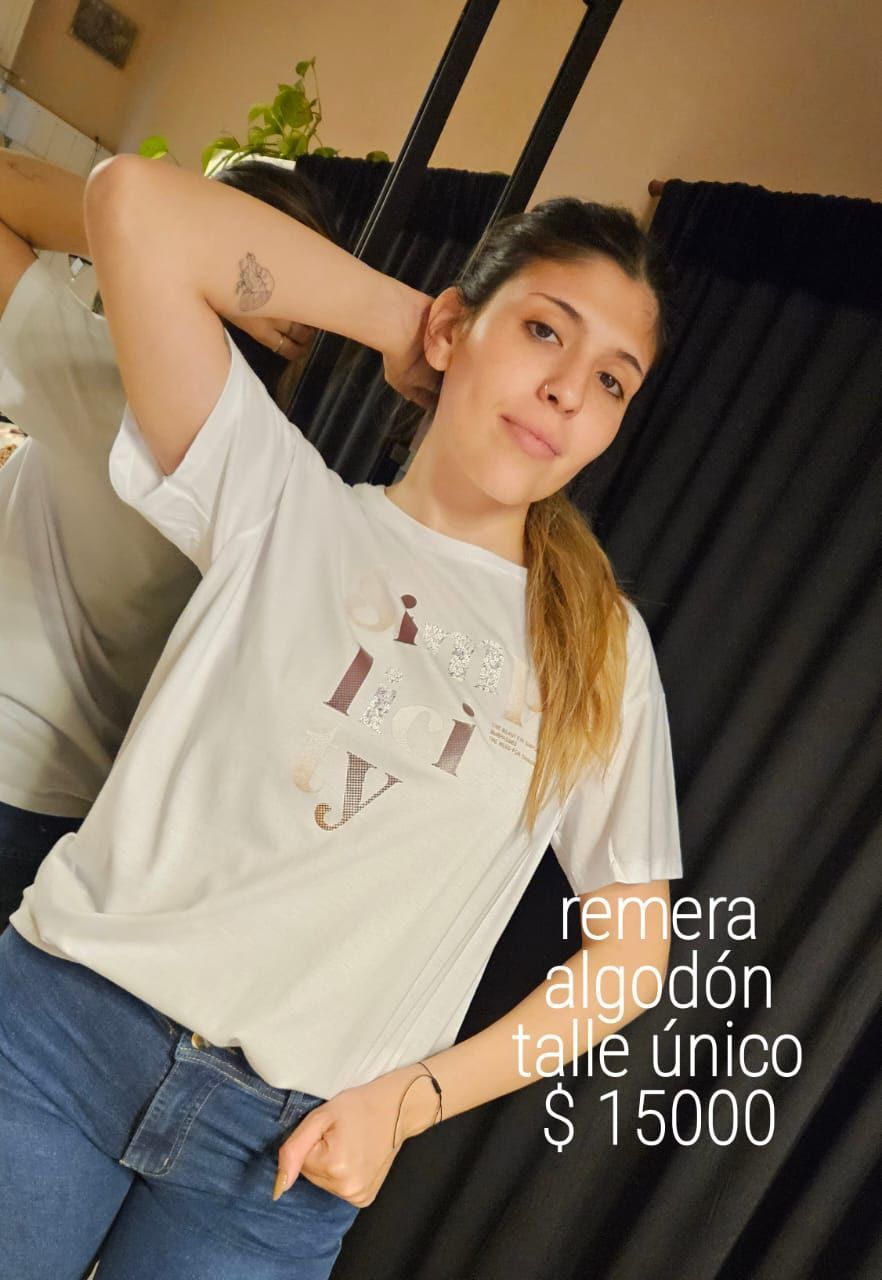 Mujer con camiseta blanca y vaqueros, posando en interiores. Texto superpuesto: 