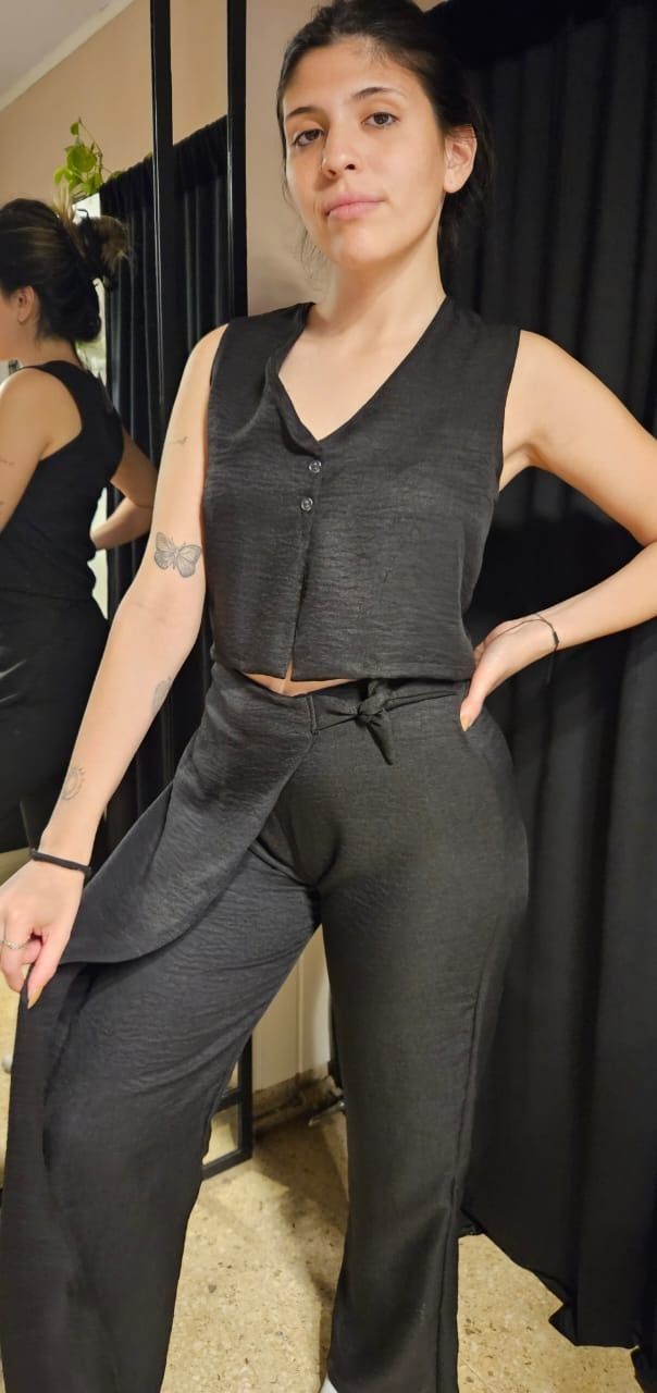 Un jarrón bicolor gris contiene dos flores de loto rosas con tallos delgados.