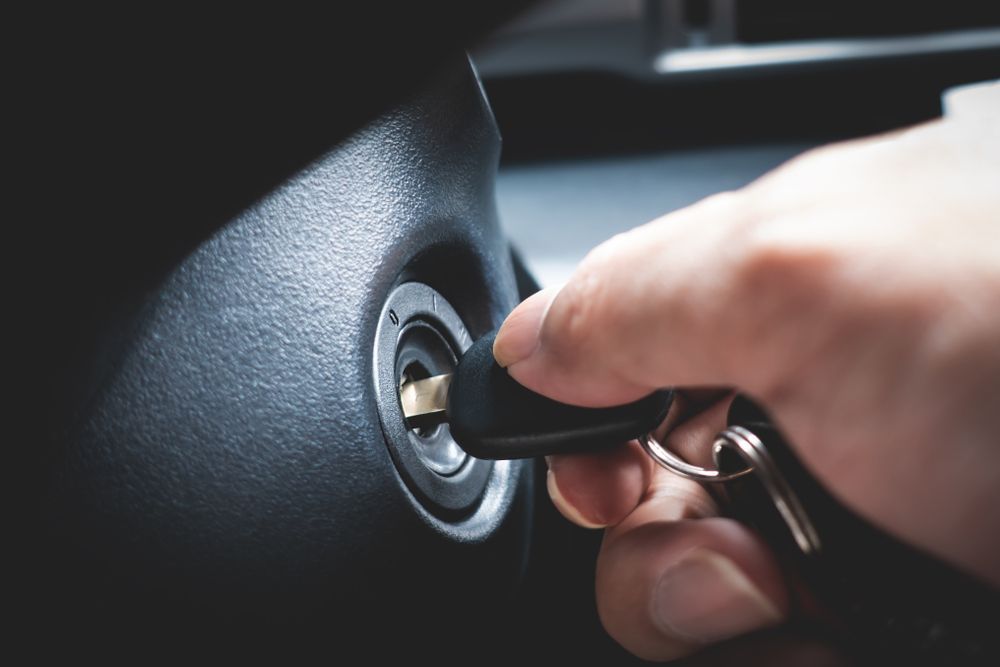 Hand Inserting a Car Key Into the Ignition Switch Inside — Terrace Locksmiths in Raymond Terrace, NSW