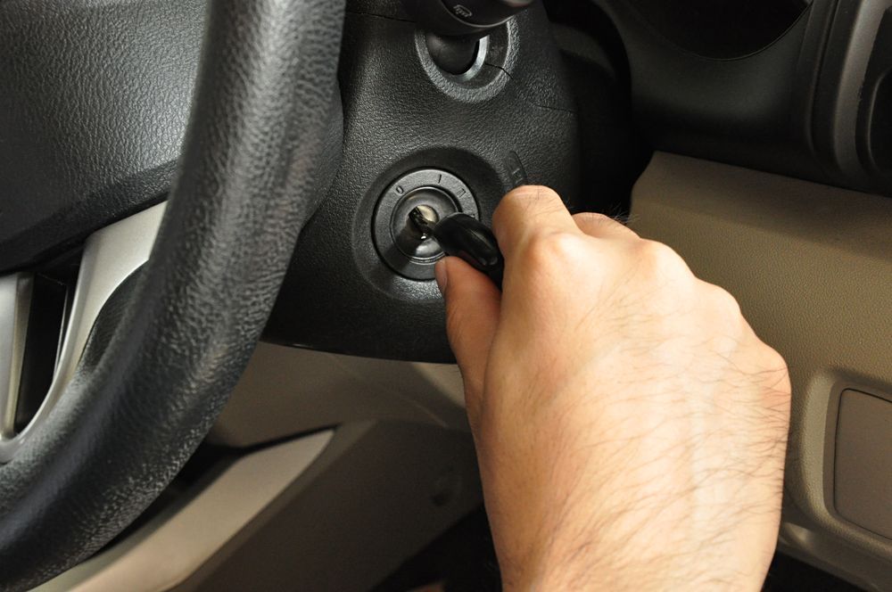 Hand Turning a Car Ignition Key on The Dashboard — Terrace Locksmiths in Raymond Terrace, NSW