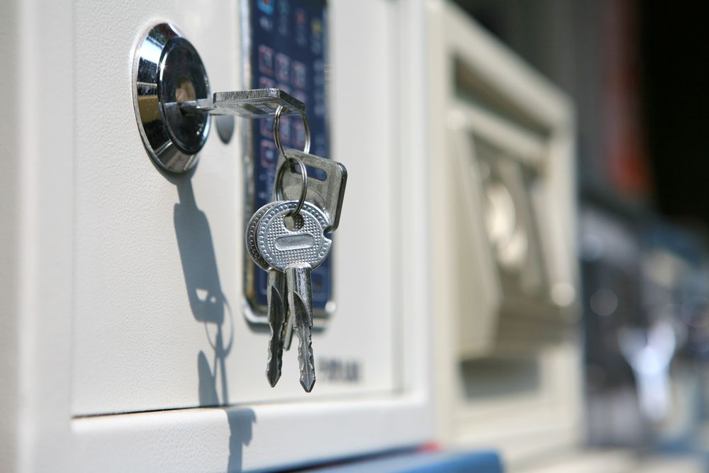 Keys in A Door Lock on A White Cabinet, with Other Locks Blurred  — Terrace Locksmiths in Raymond Terrace, NSW