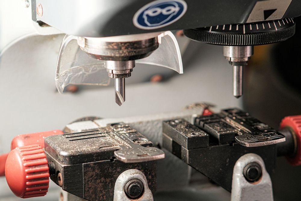 Cnc Milling Machine Cutting a Metal Piece Held in A Vise — Terrace Locksmiths in Mayfield, NSW