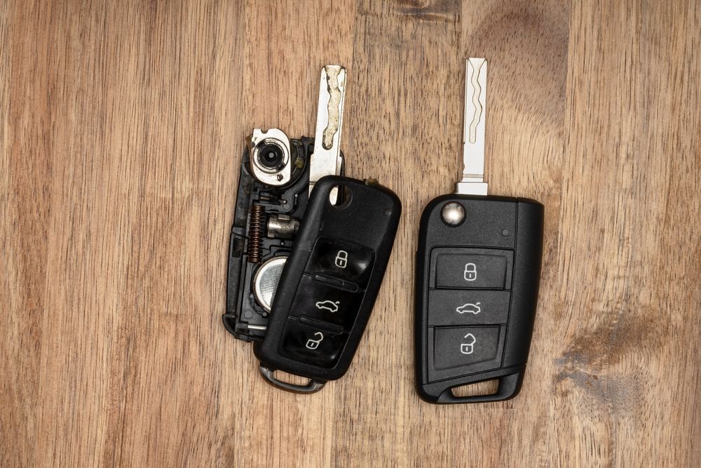 Two Black Car Key Fobs with Metal Keys on A Wooden Surface — Terrace Locksmiths in Raymond Terrace, NSW
