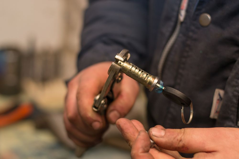 Hands Holding a Metal Hose Nozzle or Connector with A Black Hose Attached, Indoors — Terrace Locksmiths in Mayfield, NSW