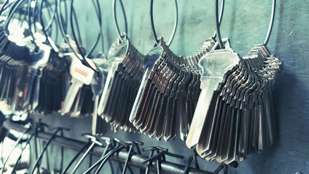 Rows of Metal Keys Hanging on Hooks in A Workshop, with A Blue-Gray Background — Terrace Locksmiths in Lake Macquarie, NSW
