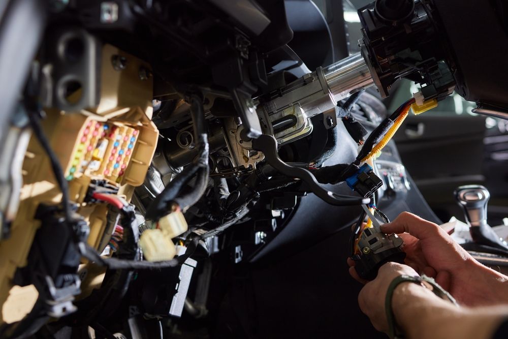 Hands Working with Wiring Inside a Vehicle Dashboard During Repairs — Terrace Locksmiths in Raymond Terrace, NSW