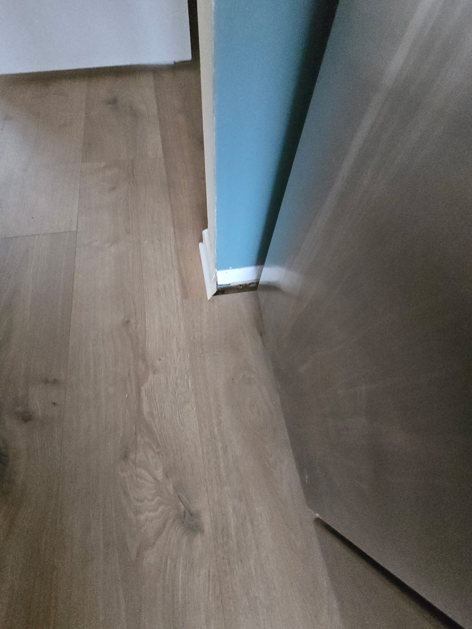 A close up of a wooden floor next to a door.