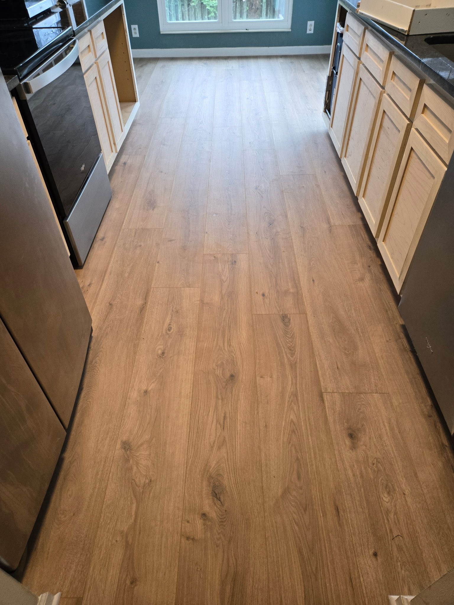 A kitchen with hardwood floors and stainless steel appliances.