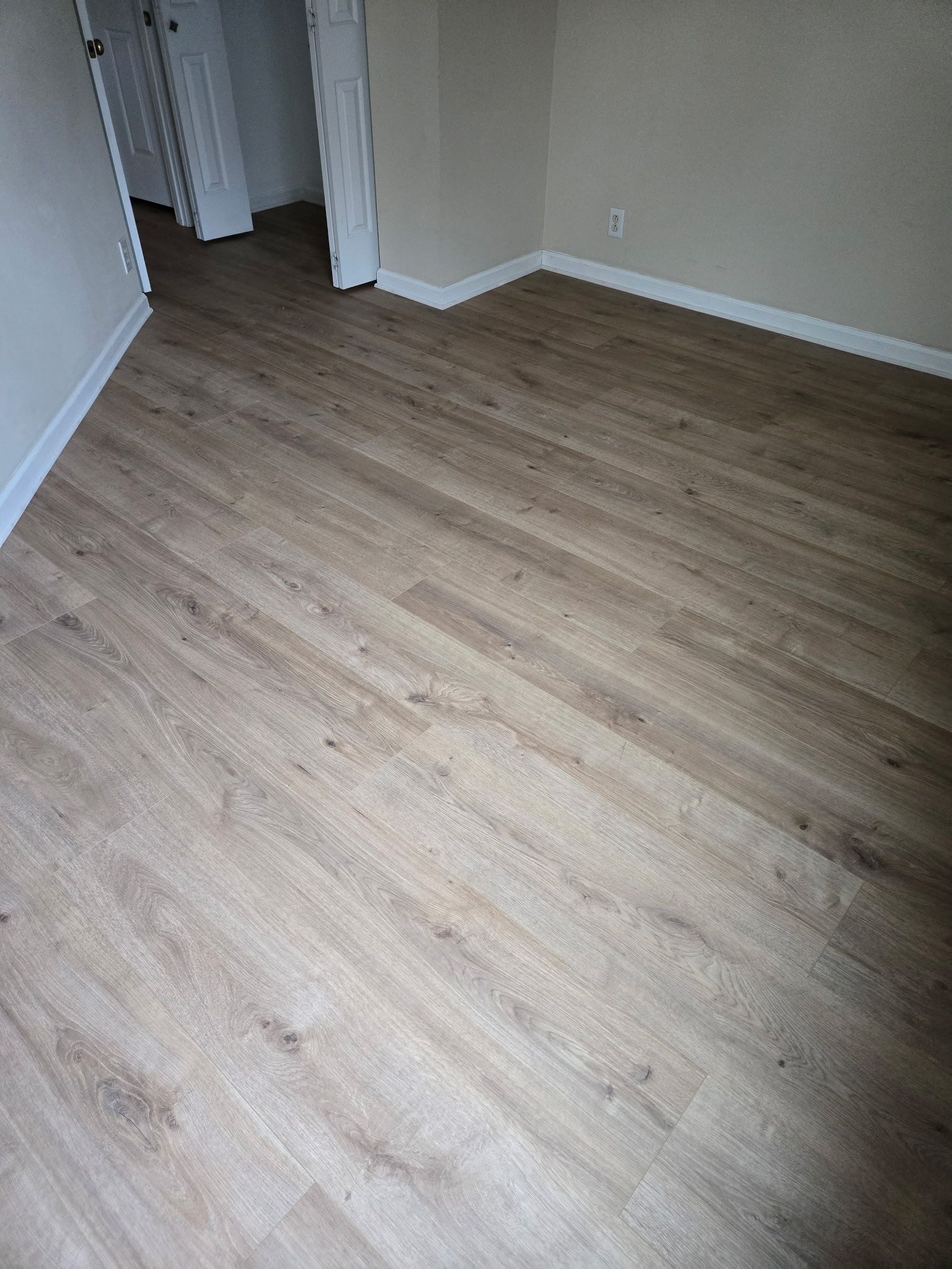 A bedroom with a wooden floor and a closet.