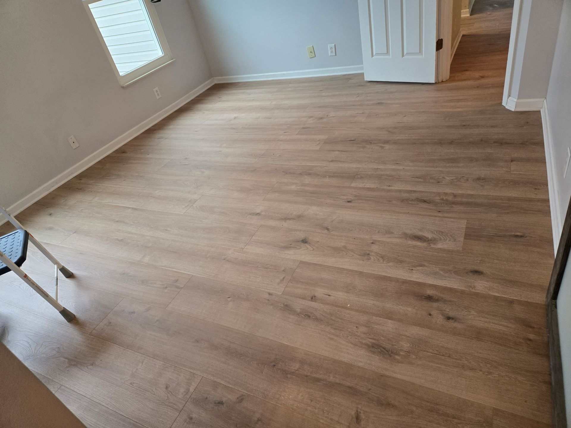 A room with a wooden floor and a window.
