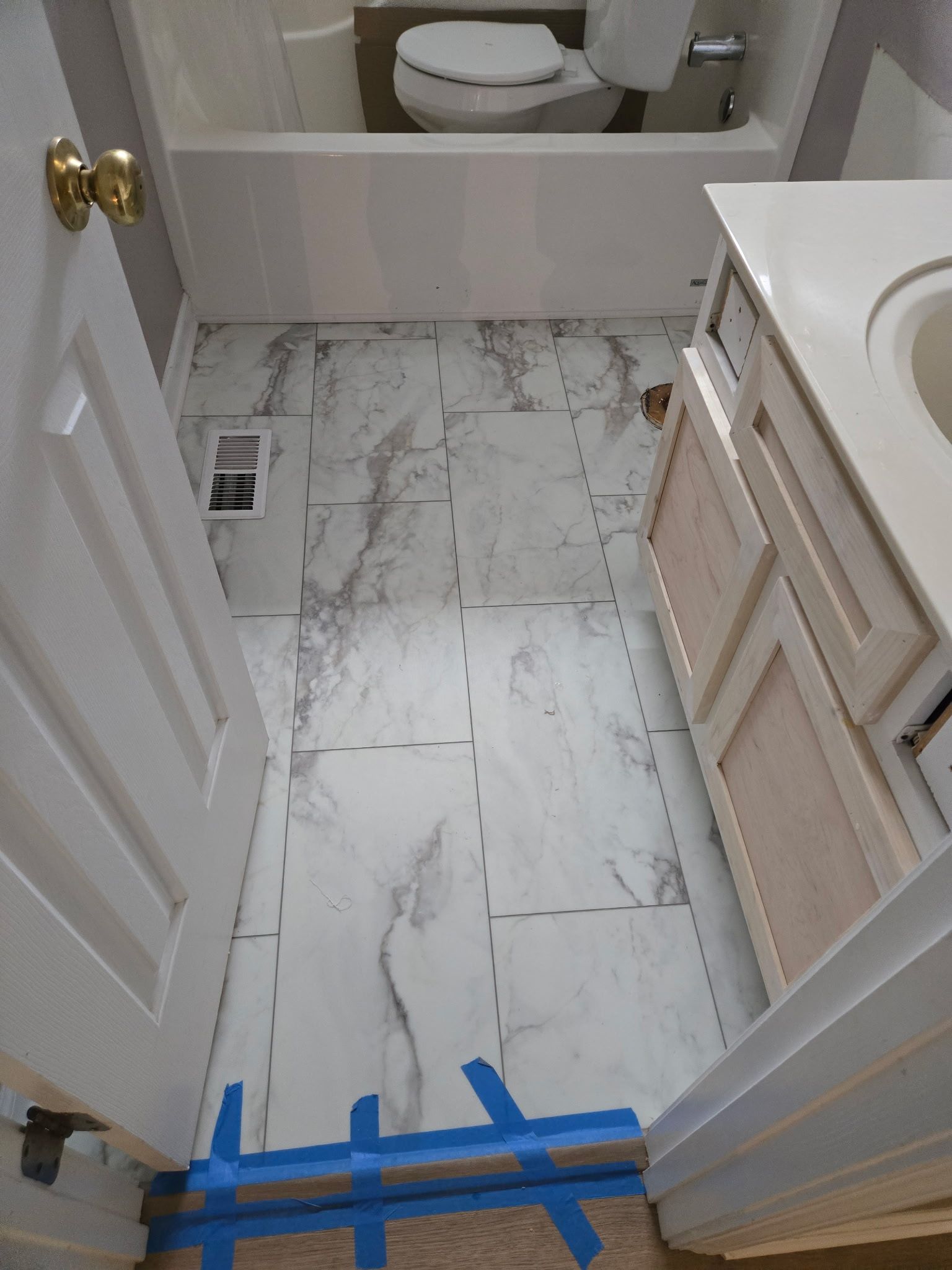 A bathroom with a marble floor and a toilet.