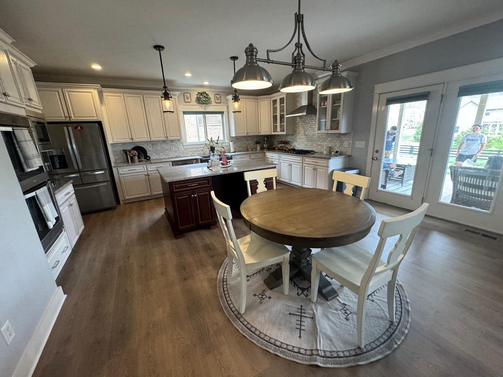 A kitchen with a round table and chairs in it.