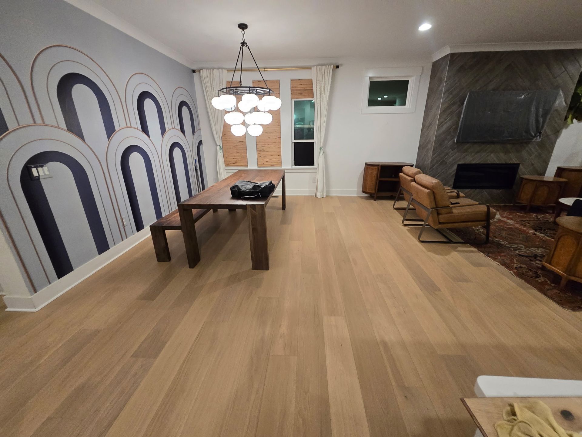 Dining room with wood floors, a dark wood table, and a mural wall.