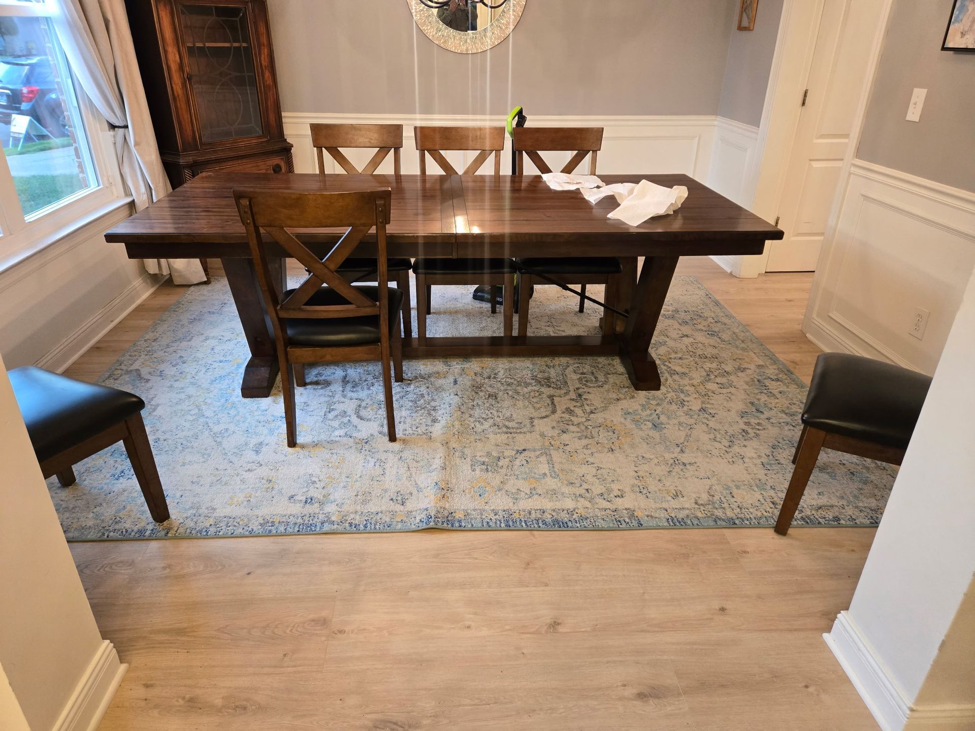 Dining room with a wooden table, chairs, and a rug.