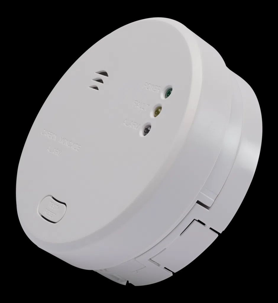 A Woman Is Pointing Up At A Smoke Detector On The Ceiling — FNQ Smoke Alarms & Maintenance In Mission Beach, QLD