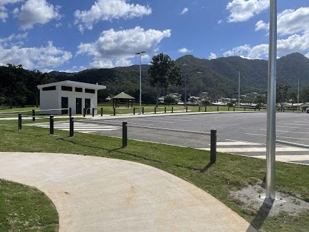 A Parking Lot With A White Building In The Background — FNQ Smoke Alarms & Maintenance In Mount Sheridan, QLD