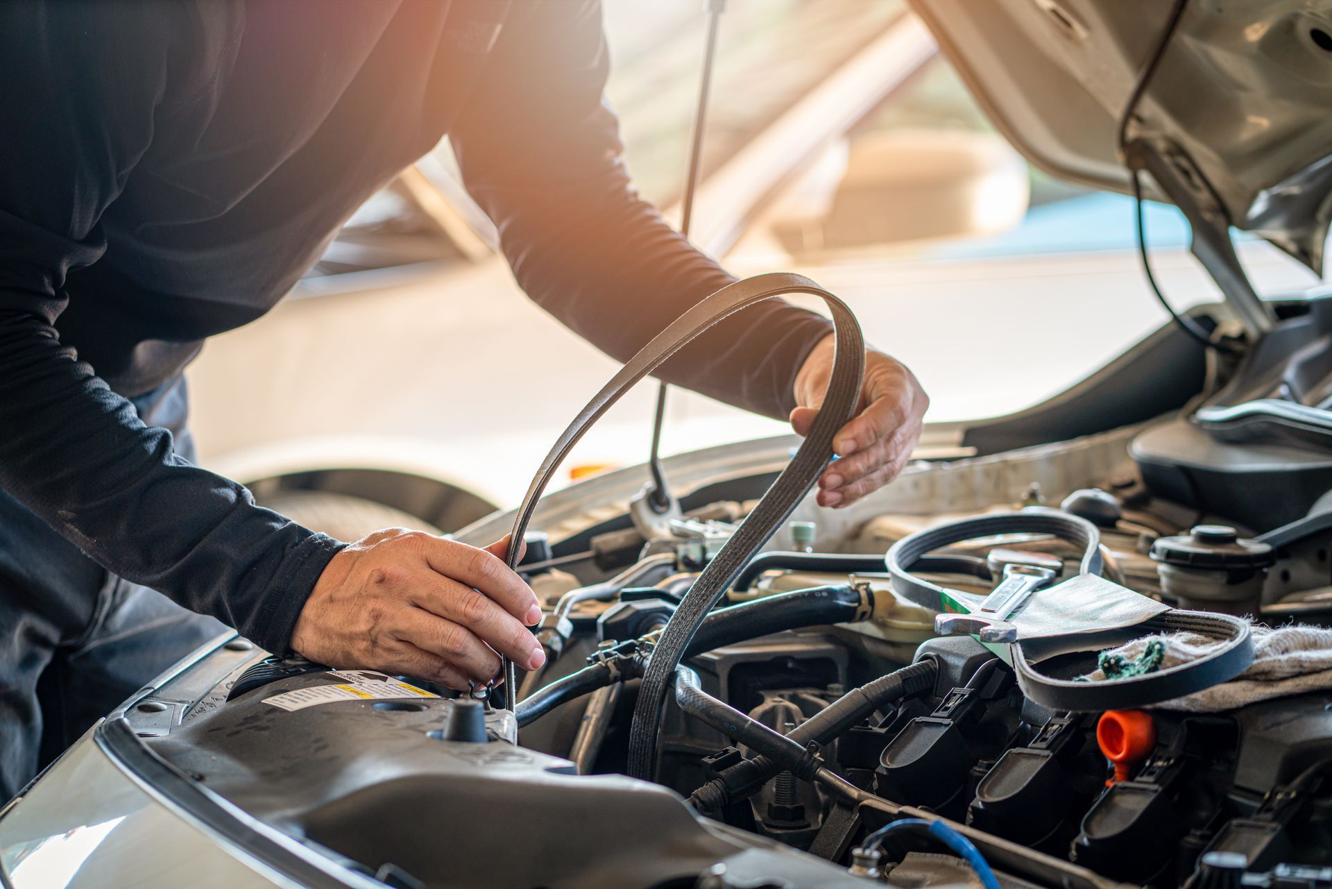 A professional mechanic man holding the timing belt of a car for repair A professional mechanic man holding the timing belt of a car for repair