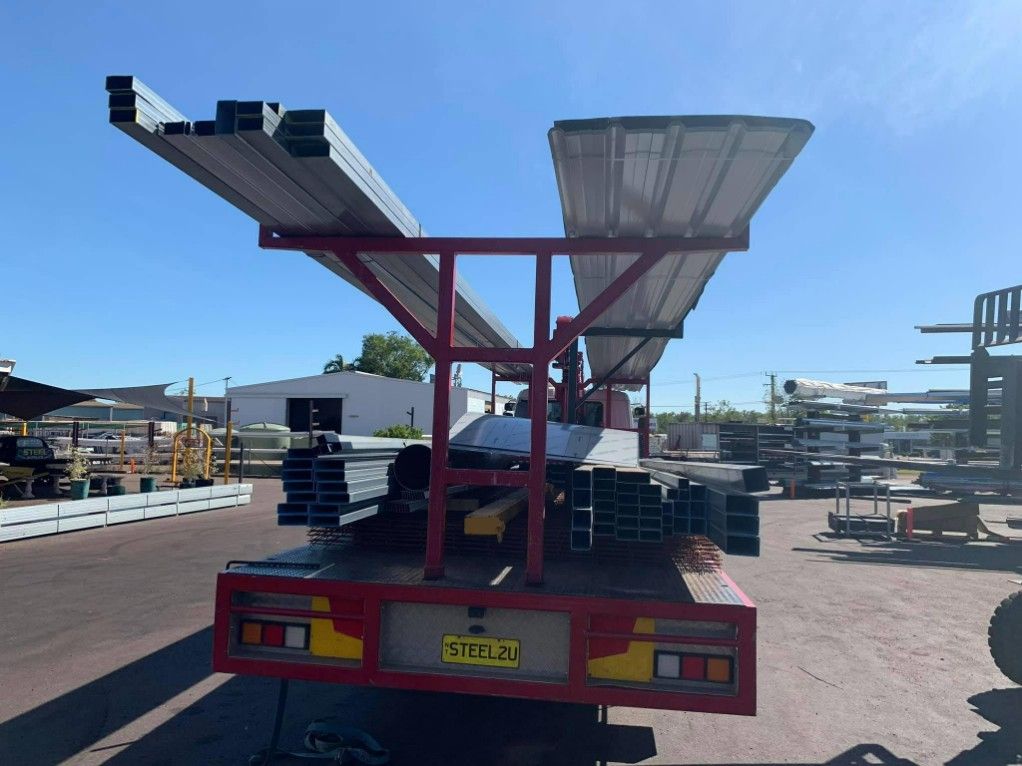 A Red Truck is Carrying a Bunch of Steels — Top End Steel Supplies Darwin In Pinelands, NT