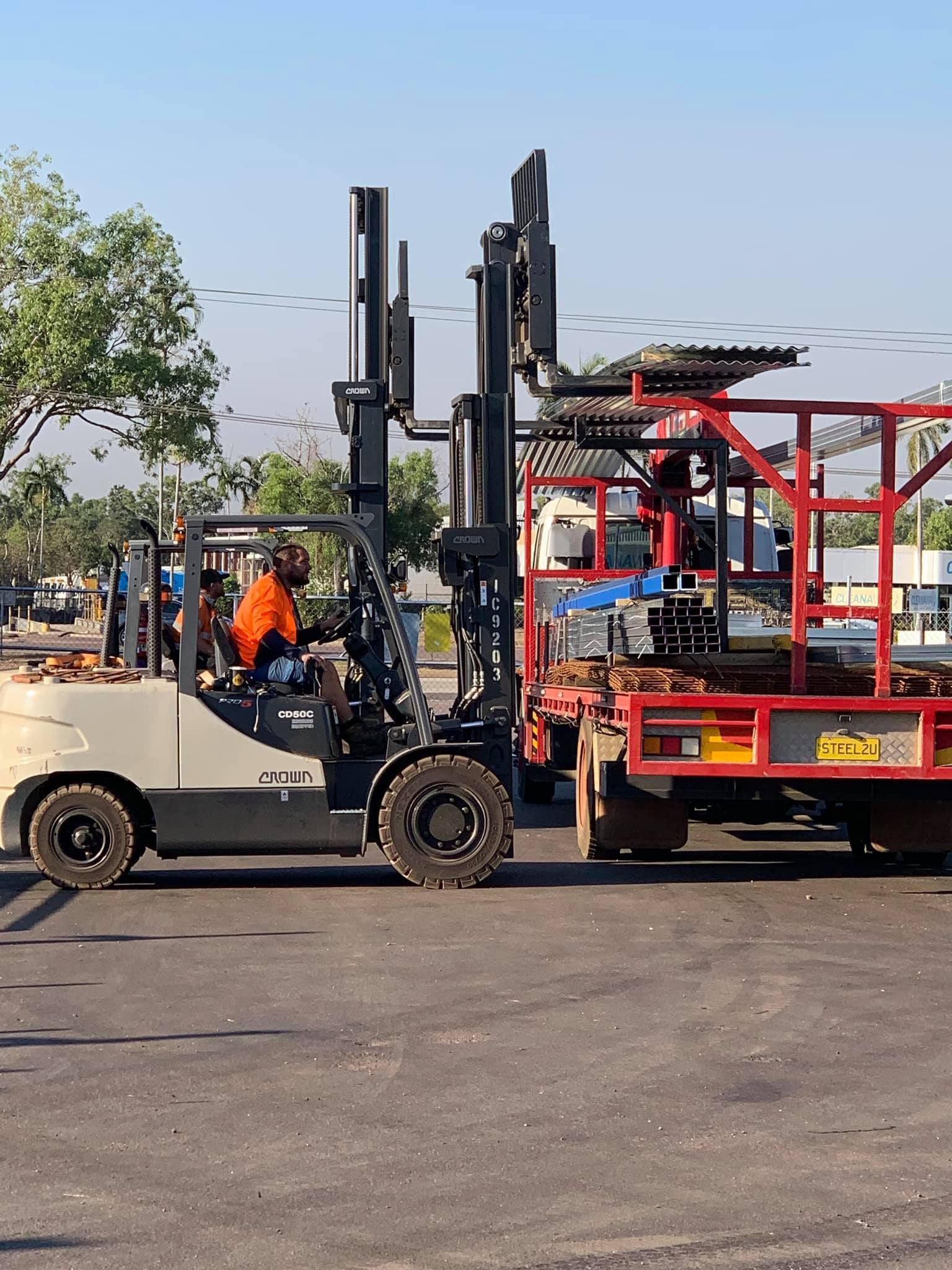 man driving a golf cart next to a truck — Top End Steel Supplies Darwin In Pinelands, NT