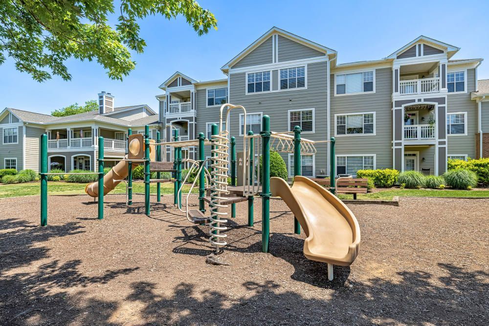 a playground with a slide and stairs in front of a building at The Preserve at Ballantyne Commons in Charlotte, NC.