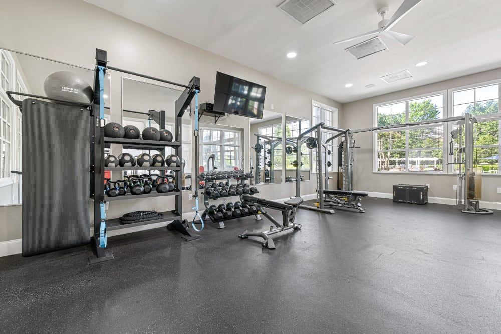 a large gym with a lot of equipment and a ceiling fan at The Preserve at Ballantyne Commons in Charlotte, NC.