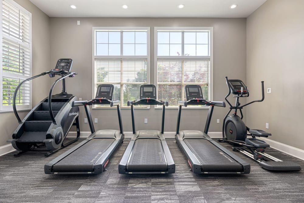 a gym with treadmills , ellipticals , and stair climbers at The Preserve at Ballantyne Commons in Charlotte, NC.